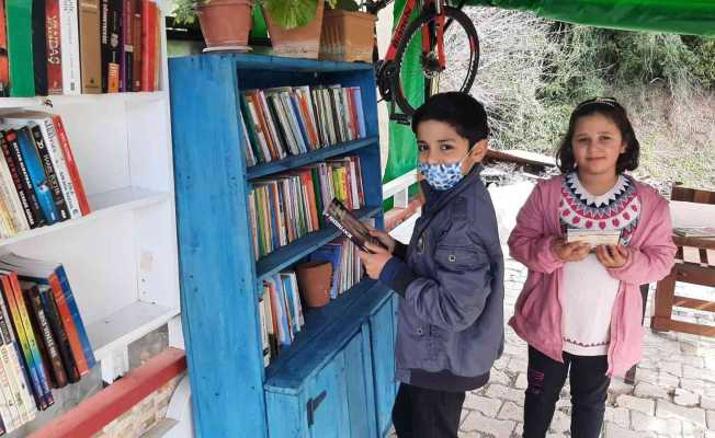 Evin bahçesine kurduğu kütüphanede mahallece kitap okuyorlar